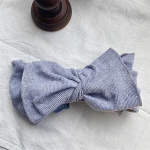 Close-up of retro lavender ribbed knit large bow headband with soft elastic texture.
