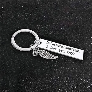Detail of stainless steel keychain engraved with 'Drive safe handsome' and wing charm