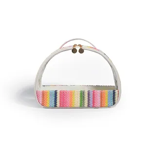 Clear PVC cosmetic bag with a colorful rainbow straw base and double gold zippers.