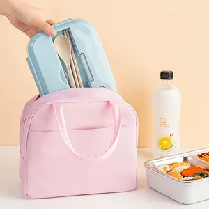 Portable insulated lunch bag in pink, holding a blue bento box for outdoor picnic.