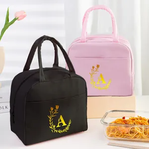 Close-up of insulated lunch bags with golden letter A print and durable handles