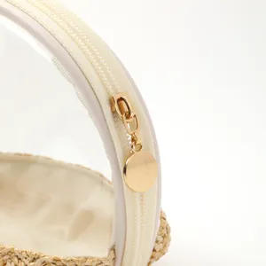 Close-up of gold metal zipper on portable waterproof straw woven cosmetic travel bag