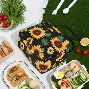 Sac à lunch isotherme à motif de tournesol présenté dans un décor de pique-nique coloré