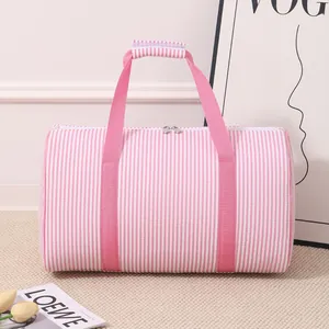 Close-up of pink seersucker striped travel bag with durable pink handles and zip