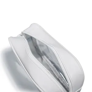 Detalle superior de un neceser de PVC blanco abierto que muestra el compartimento