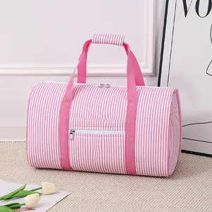Detailed view of pink and white striped seersucker travel bag with zipper pocket