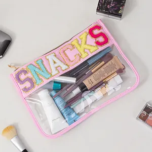 Detailed view of clear PVC storage bag featuring colorful SNACKS chenille embroidery