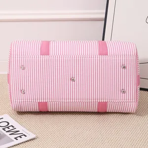 Bottom view of pink seersucker striped travel bag with protective metal feet