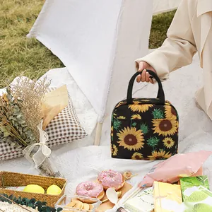 Gros plan d'un sac à lunch isotherme avec imprimé tournesol dans un décor de pique-nique