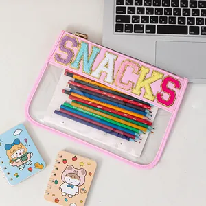 Macro view of transparent pink PVC storage bag with colorful SNACKS embroidery detail