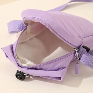 Detailed view of the spacious white interior of this purple nylon crossbody bag.