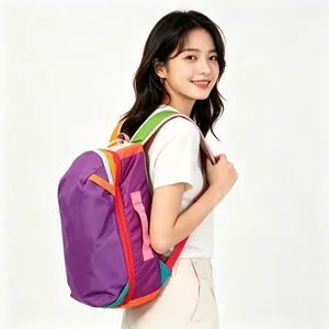Close-up of vibrant color-blocking waterproof nylon backpack worn by a model in profile.