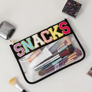 Detailed view of a clear PVC makeup organizer bag with colorful SNACKS embroidery