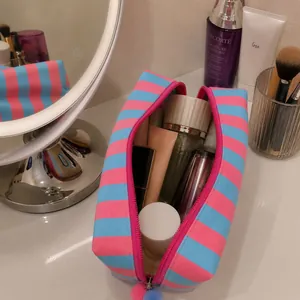 Vista dettagliata della borsa da trucco a righe con vari prodotti per la cura della pelle
