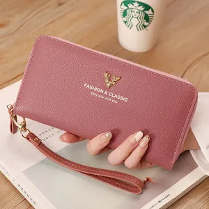 Elegant mauve litchi texture long zipper wallet with gold deer emblem held by hand