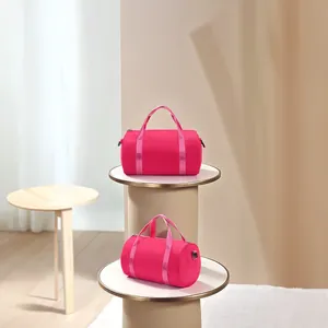 Detailed view of two hot pink cylindrical waterproof yoga dance bags on display