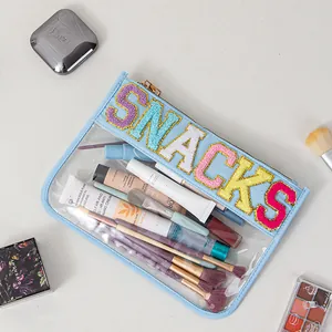 Detail of clear PVC storage bag with colorful SNACKS chenille letter patches and cosmetics