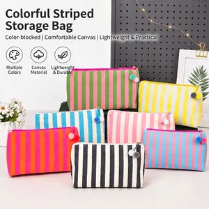 Set kleurrijke gestreepte canvas make-uptassen met decoratieve pompon-ritsen in kleuren