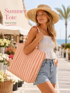 Close-up of a stylish pink striped canvas tote bag held by a model in a sunny street