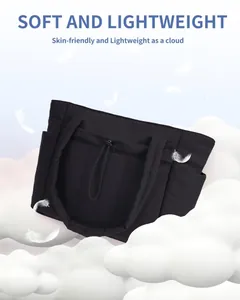 Detailed view of black quilted large capacity tote bag floating with white clouds and feathers