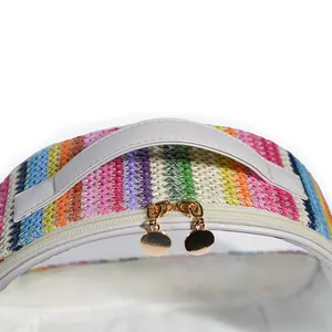 Close-up of rainbow woven straw and transparent PVC cosmetic bag with golden zippers.