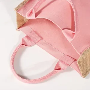 Detalle del bolso de lona rosa con asas resistentes y un práctico forro impermeable