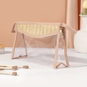 Detailed view of a transparent PVC makeup bag with straw woven trim and golden zipper