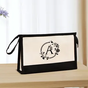Gros plan détaillé d'une pochette à maquillage en toile avec une couronne florale et la lettre A