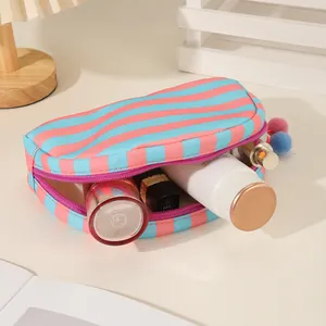 Detail van de opslagcapaciteit van een gestreepte canvas schelpvormige make-uptas