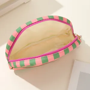 Detail van de binnenvoering en rits van de roze en groene canvas schelpvormige cosmetische tas