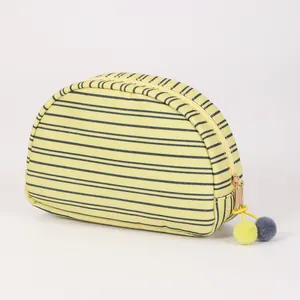 Halfronde canvas make-uptas met stijlvolle strepen en schattige pompon ritstrekker.