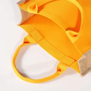 Detalle de cerca de un bolso de mano de yute y lona amarilla con asas resistentes.