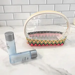 Detailed view of a transparent makeup bag with a colorful woven chevron base on marble counter