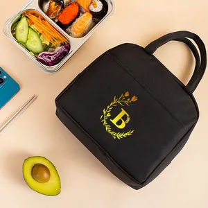 Close-up detail of insulated lunch bag featuring elegant yellow floral letter B pattern