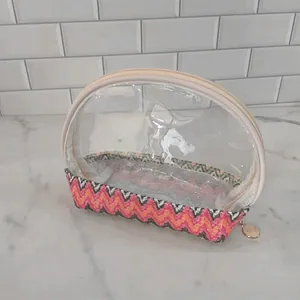 Detailed view of portable transparent cosmetic bag with colorful woven chevron base