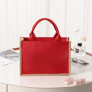 Bolso tote de lona roja y yute presentado con elegantes accesorios de estilo de vida