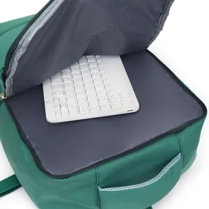Detailed view of the green laptop backpack interior showing a white keyboard storage