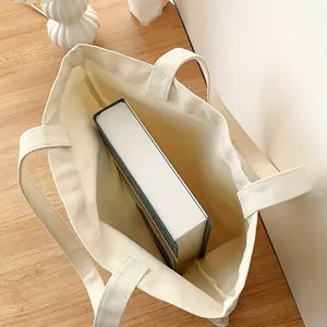 Vista interior de un espacioso bolso de lona beige que muestra su gran capacidad