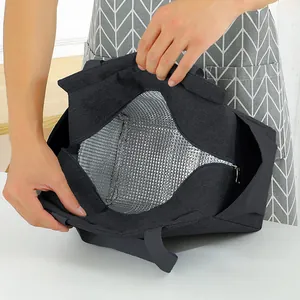 Detail view showing the thick silver aluminum foil insulation lining of the black lunch bag