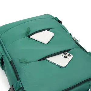 Detailed macro view of green travel backpack front pockets holding a phone and power bank