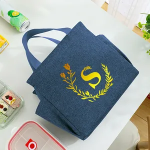 Close-up view of a portable insulated blue lunch bag featuring a yellow letter S design