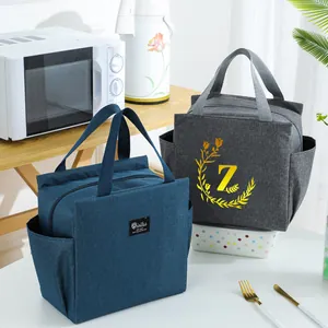 Detail view of portable insulated lunch bags in blue and grey with sturdy carry handles