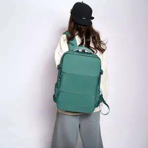 Large green travel backpack with laptop compartment shown on a model's back for scale