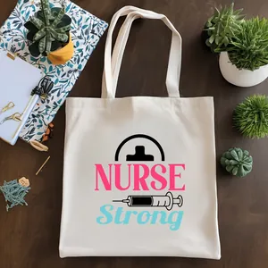 Vista detallada de un bolso de lona blanca con texto NURSE Strong y gráfico de una jeringa