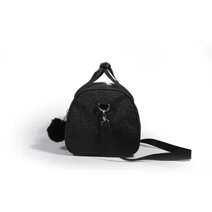 Detailed side view of a black glitter gym duffel bag featuring a soft pom-pom charm