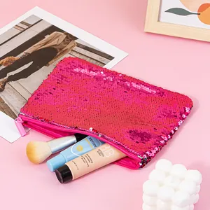 Close-up of a vibrant pink sequined cosmetic bag with makeup accessories on a pink background.