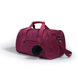 Close-up view of a magenta glitter sport duffle bag with a decorative black pom-pom