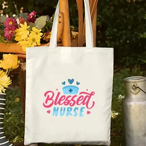 Detalle de la bolsa de lona estampada Blessed Nurse en un jardín al aire libre muy soleado.