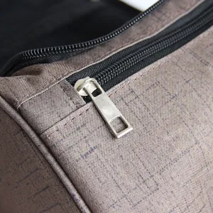 Détail du zip métallique et du tissu texturé durable de la trousse de toilette
