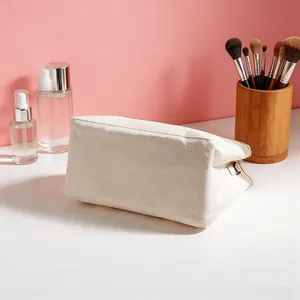 Vista detallada del fondo resistente y la hebilla lateral de un bolso de lona beige.